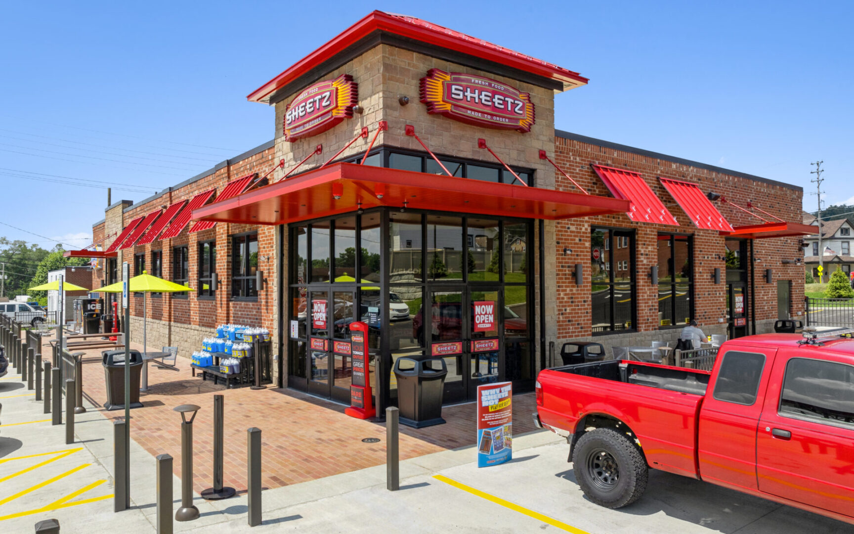 Brick convenience store with red accents outside.